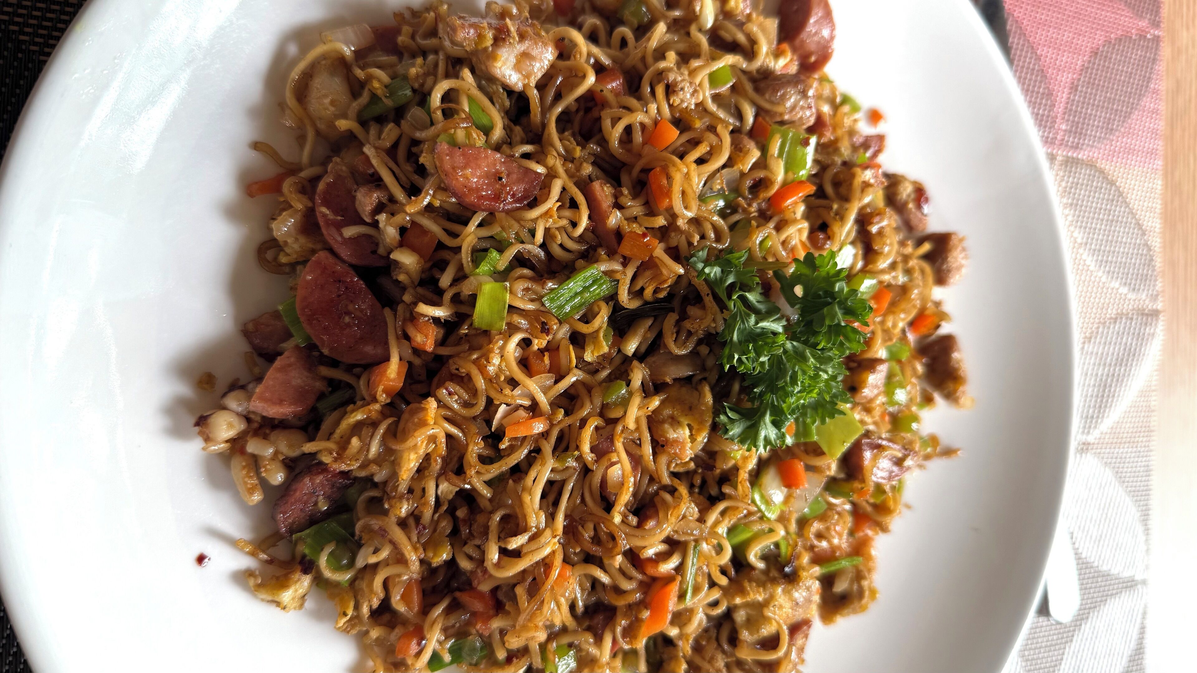 Un plato de fideos salteados con verduras y carne.