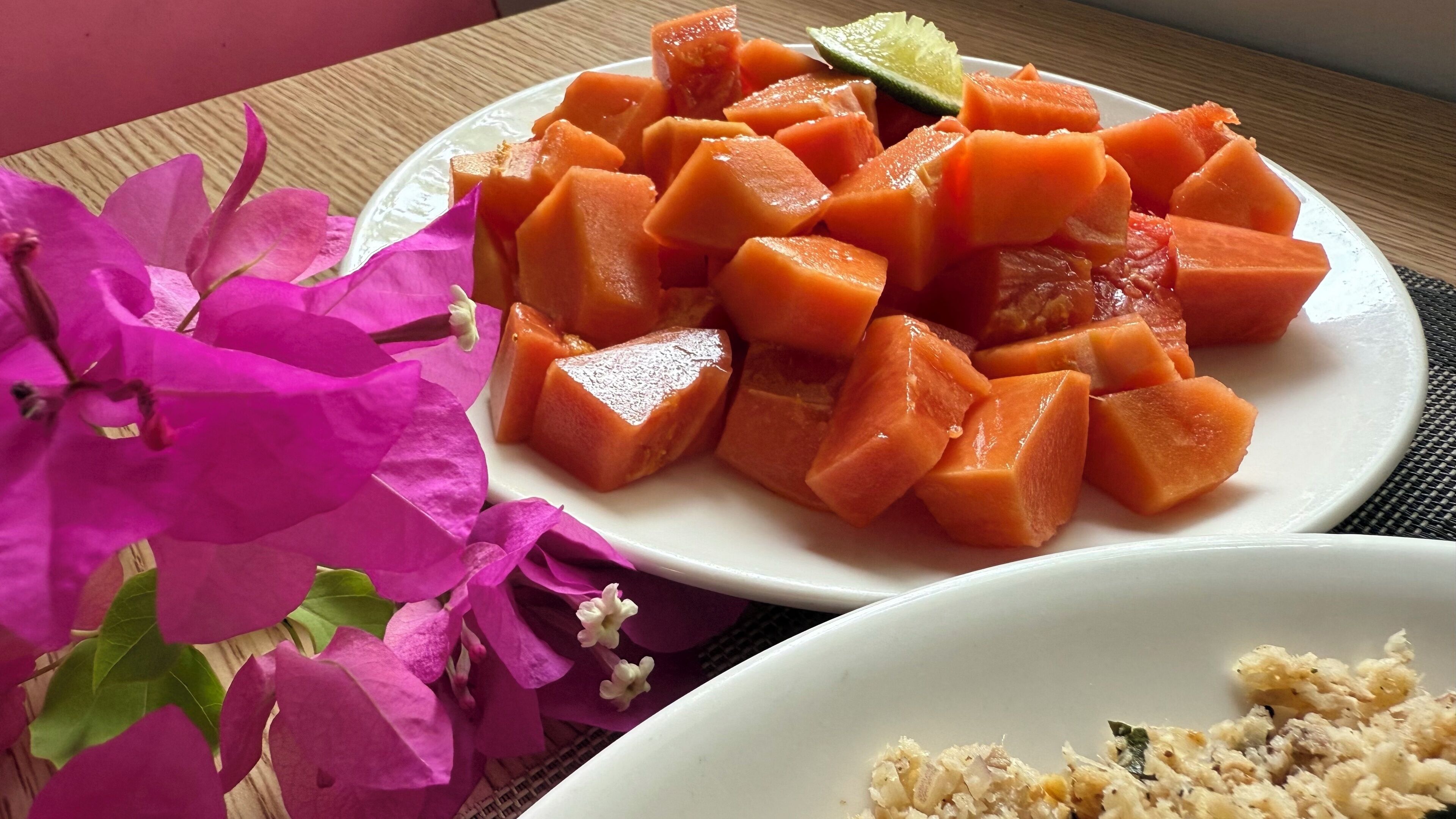 Un plato con trozos de fruta, posiblemente melón, y un gajo de lima encima.