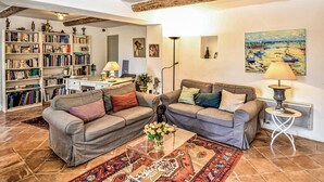 A cozy living room with two sofas, a coffee table, and a bookshelf filled with books.