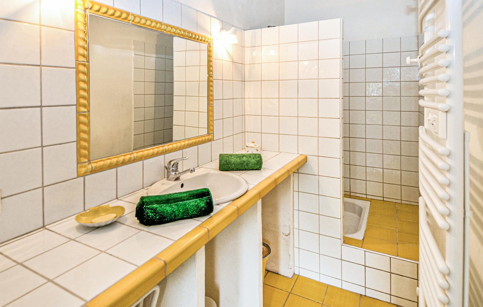 Ein Badezimmer mit Waschbecken, Spiegel und Dusche.