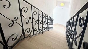 A staircase with black metal railings and beige steps. - L’instant rose - Cocon fleuri avec jacuzzi (Quéven)