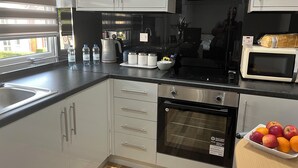 Una cocina moderna con electrodomésticos de acero inoxidable, horno integrado y microondas.