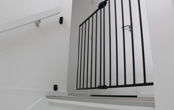 A white staircase with a black metal railing.