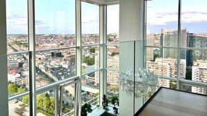 Ein Hotelzimmer in einem Hochhaus mit großen Fenstern und Blick auf die Stadt.