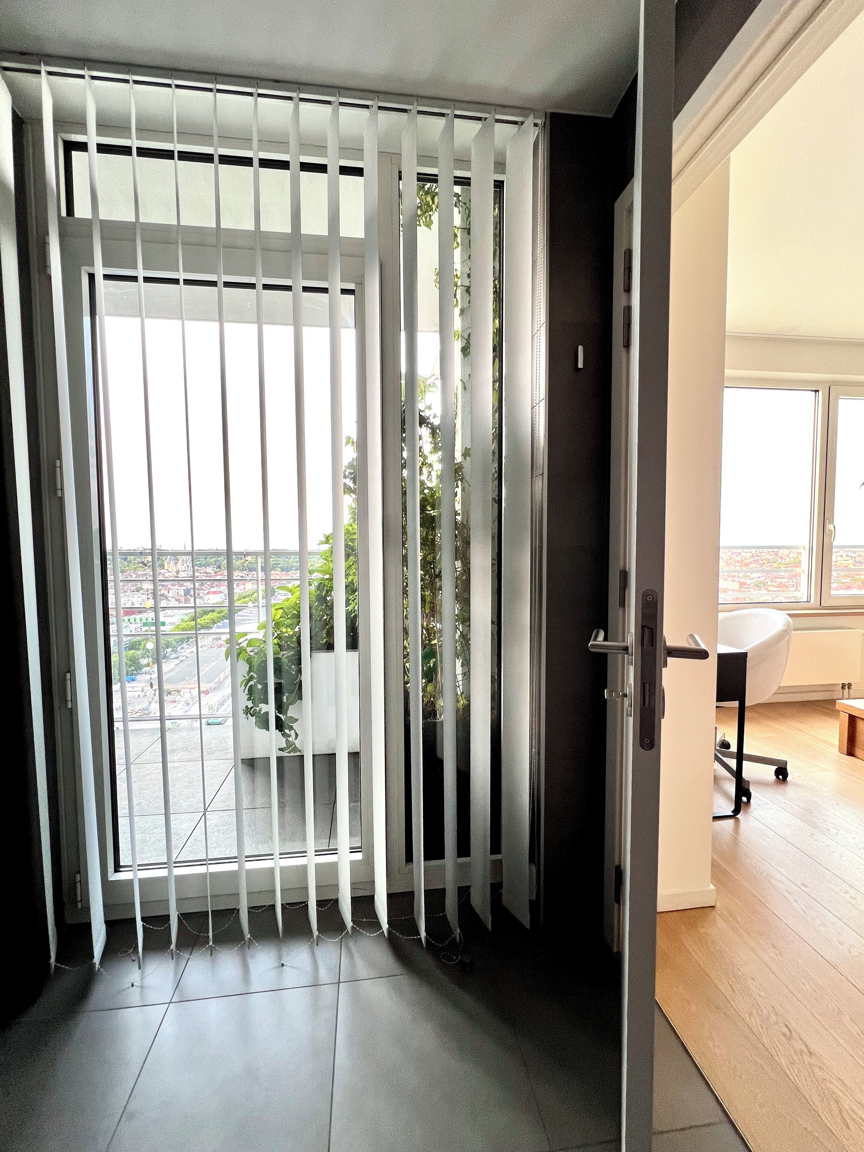 A room with a view through a barred window, a desk, and a chair.
