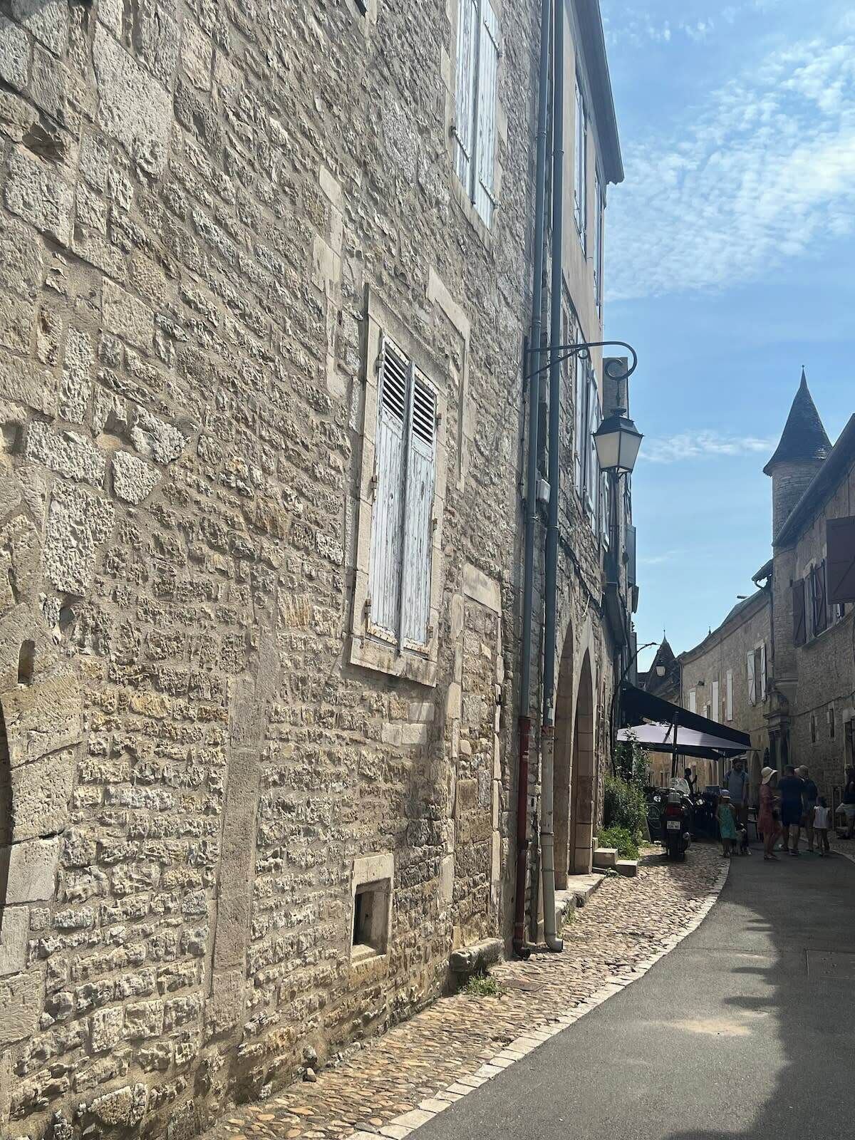 A stone building with a narrow street in front.