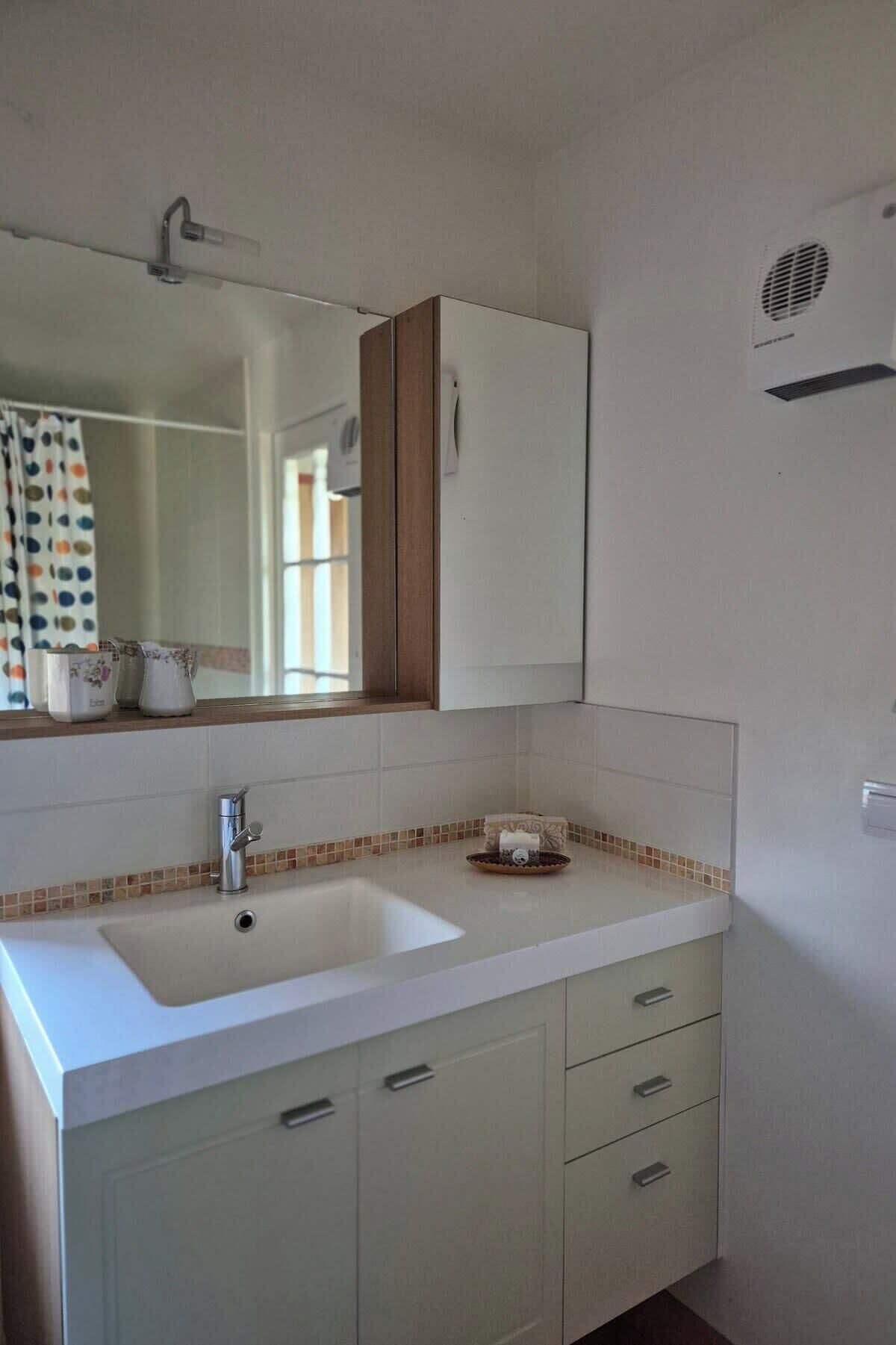 A bathroom with a double sink, a mirror, and a cabinet.