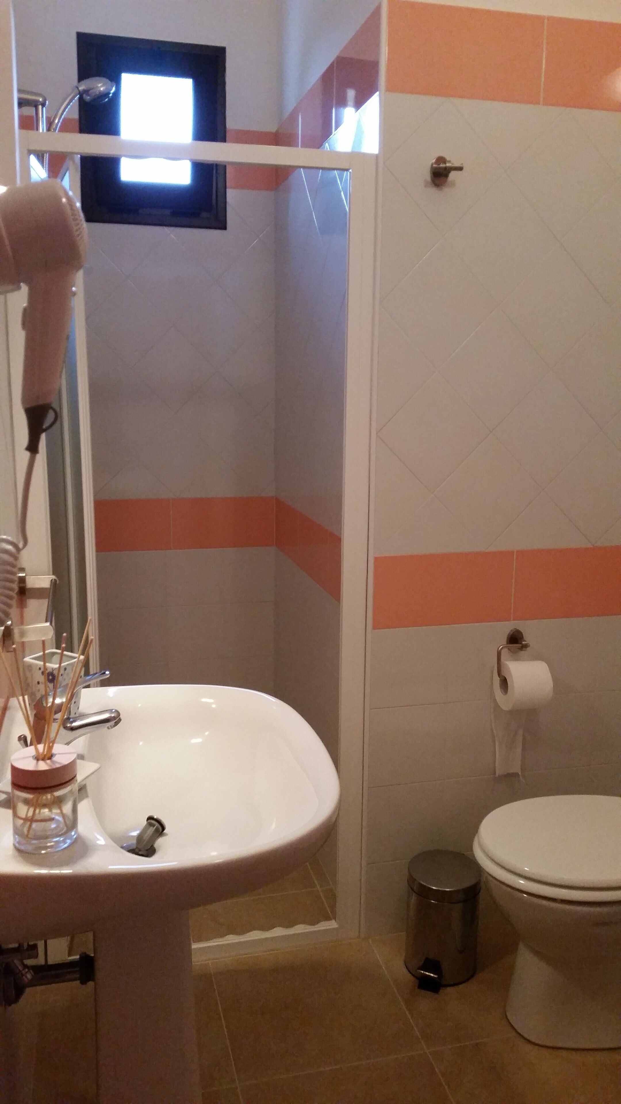 A bathroom with a sink, toilet, and a shower area.