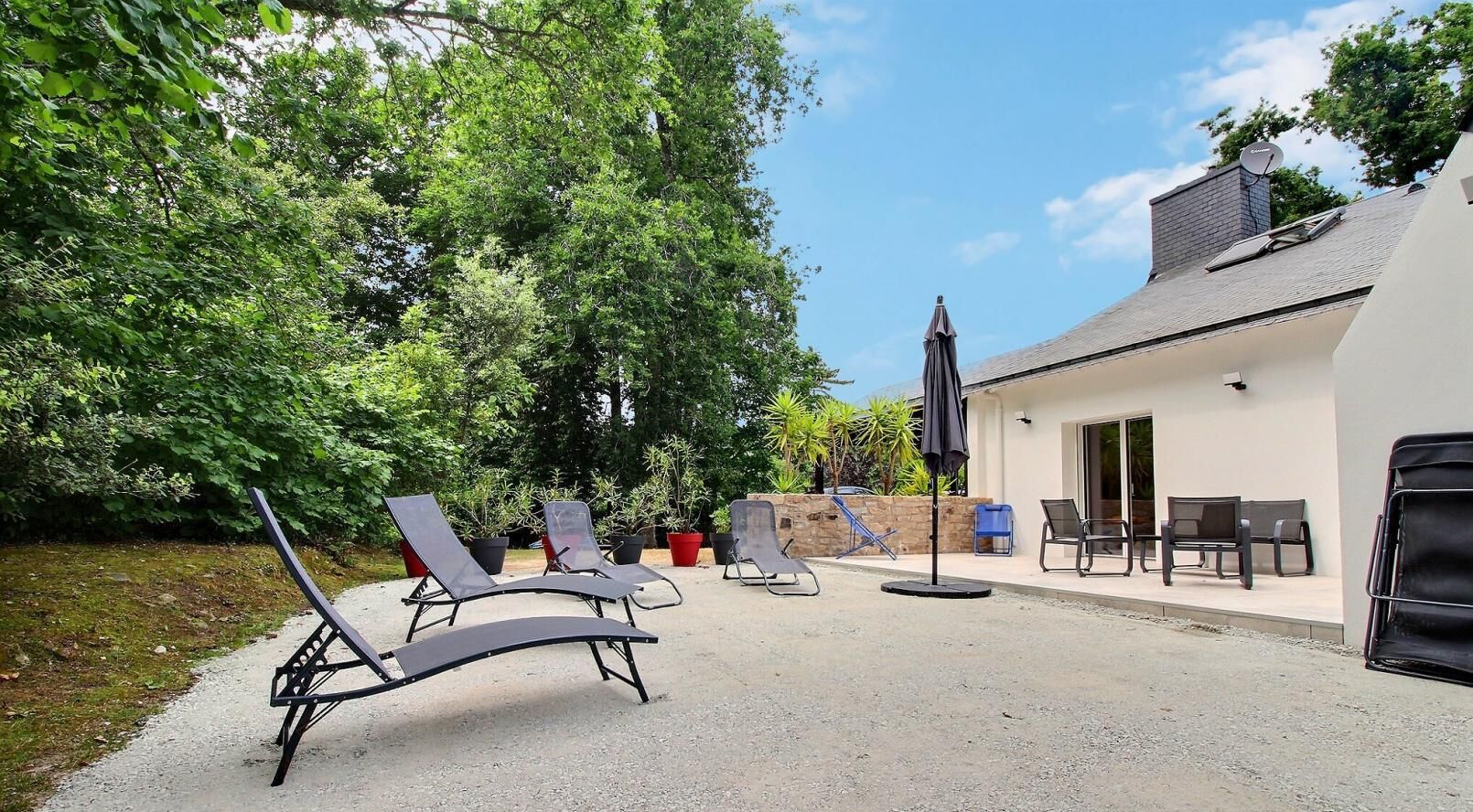 Un patio con mobiliario exterior y una parrilla.