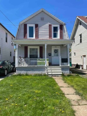A two-story house with a front porch, a garage, and a driveway.