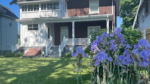 A two-story house with a front porch and a small front yard. - Spacious ♥ Niagara Falls♥A/C♥Parking♥Steam Shower (Niagara Falls)