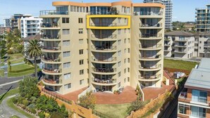 Un hotel de varios pisos con balcones, un patio central y vistas del entorno.