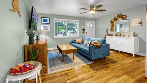 Ein Wohnzimmer mit blauem Sofa, Couchtisch aus Holz und einem weißen Schrank.