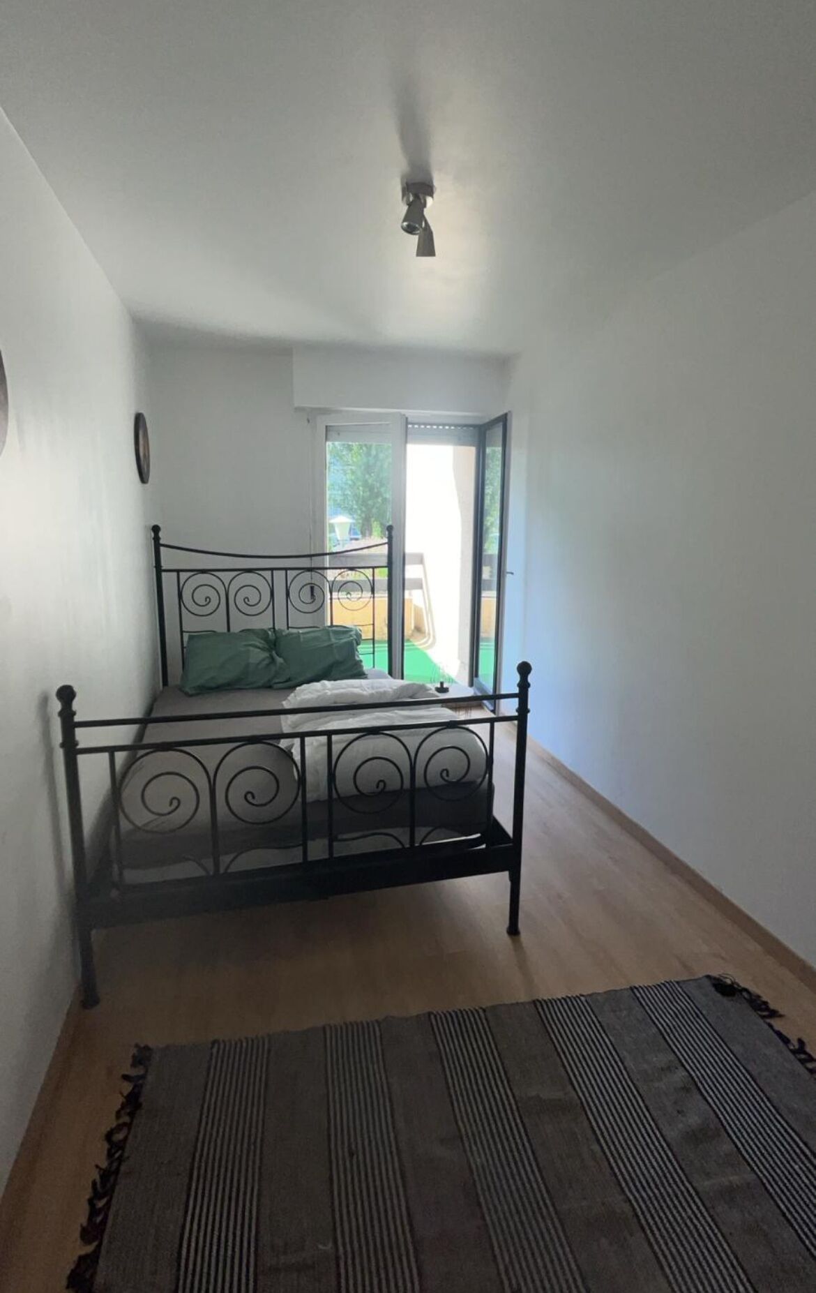 Een slaapkamer met een bed, een plafondventilator en uitzicht op de omgeving.