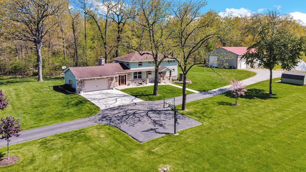 A two-story house with a garage, a covered porch, and a well-maintained lawn.