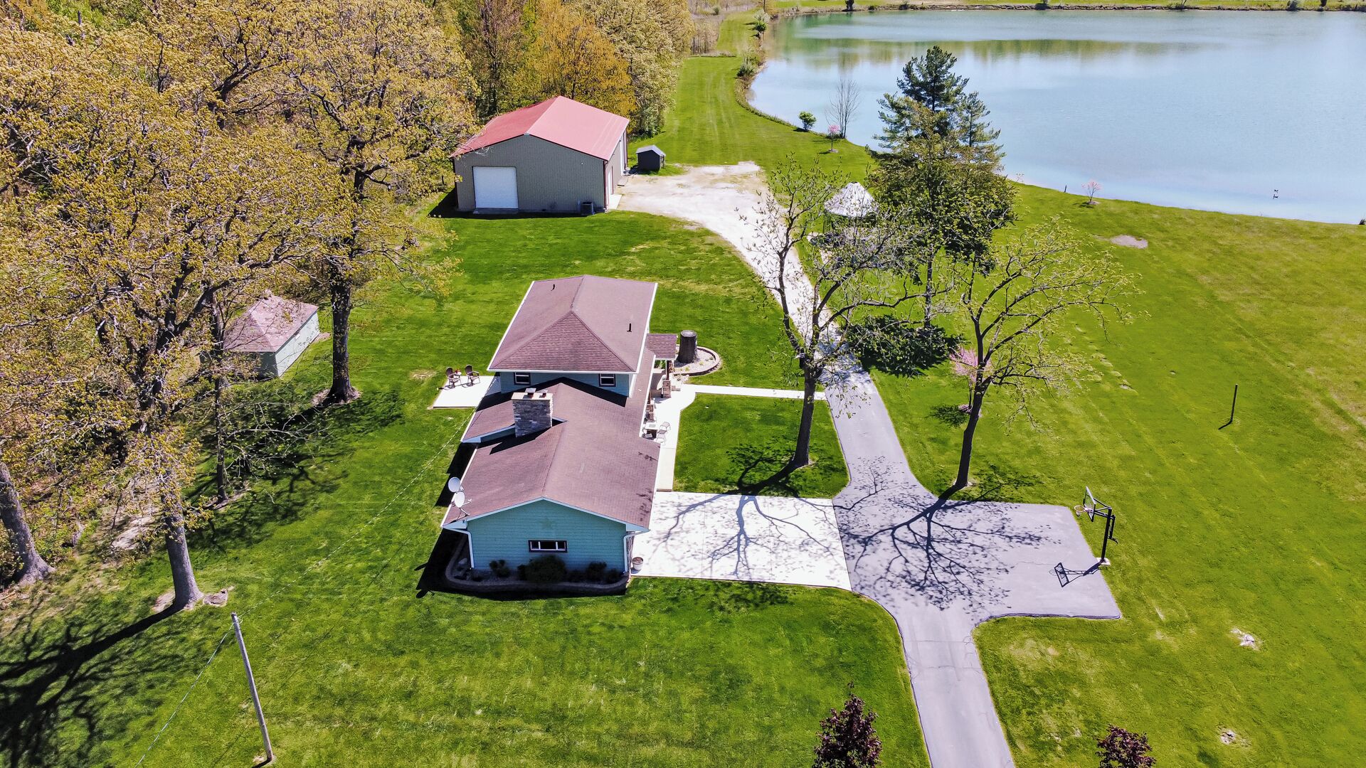 A residential area with a house, a garage, and a pond.
