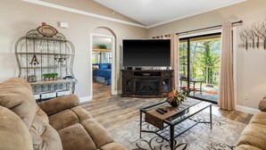 A living room with a fireplace, a television, and a sofa. - Cozy Comfort Retreat For 6 (Branson)
