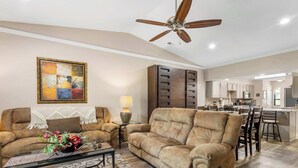 A living room with a sofa, coffee table, and a painting on the wall. - Cozy Comfort Retreat For 6 (Branson)