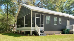A single-story house with a covered porch, large windows, and a small front yard. - Charming 3-bedroom home within walking distance to  downtown area/FLETC friendly (Darien)