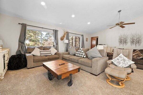 A living room with a sofa, a coffee table, and a recliner.