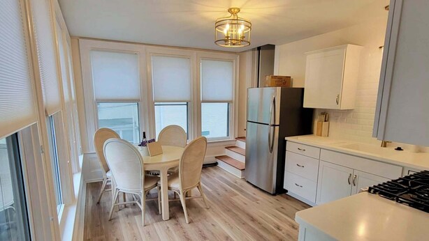 Una cucina moderna con zona pranzo, ampie finestre e vista sul mare.