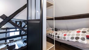 A bunk bed with a polka dot bedspread, a black metal staircase, and a white wall. - Loft à Arras • 3 ch • 7 personnes • hypercentre (Arras)