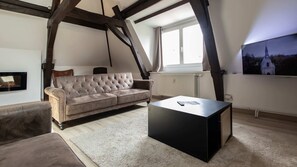 A modern living room with a sofa, a coffee table, and a TV mounted on the wall. - Loft à Arras • 3 ch • 7 personnes • hypercentre (Arras)