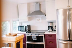 A kitchen with a microwave, oven, and stainless steel refrigerator.