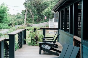 A wooden deck with outdoor seating and a view of a garden. - 2BR Folly Cottage 1-block from the beach! (Folly Beach)