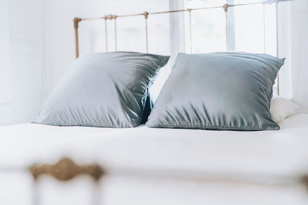 A bed with a metal headboard and two pillows.