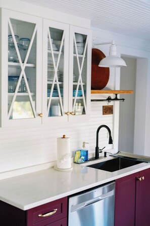 A kitchen with a white countertop, a stainless steel dishwasher, and a sink with a black faucet. - 2BR Folly Cottage 1-block from the beach! (Folly Beach)