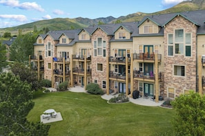 A multi-story hotel with balconies, a courtyard, and a mountainous backdrop.