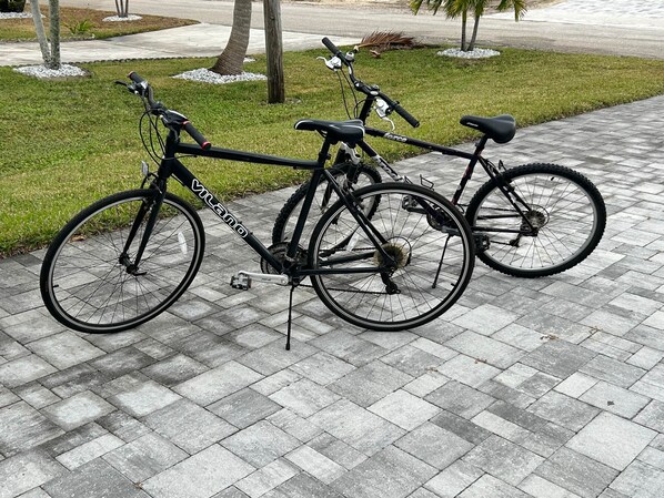 Two bicycles parked on a paved walkway.