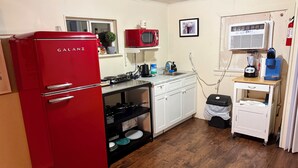 A compact kitchen with a red refrigerator, a microwave, a sink, and a coffee maker. - Cozy Waterfront Cabin Minutes from the Beach (Palacios)