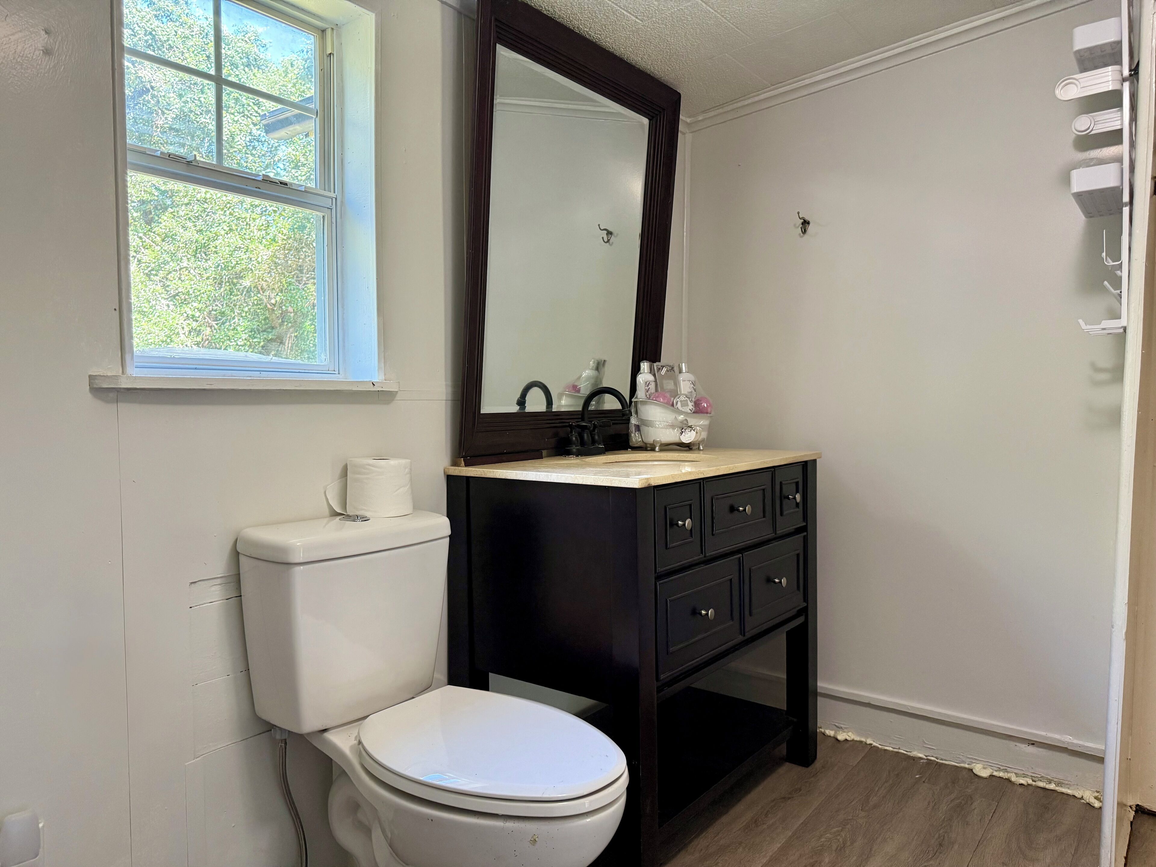 A bathroom with a toilet, sink, and mirror.