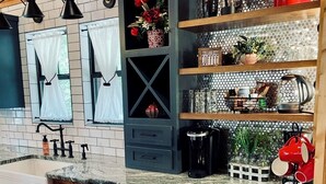 Eine Küche mit Marmorarbeitsplatte, einem eingebauten Schrank mit Schublade, einer Kaffeestation und einem roten Wasserkocher.