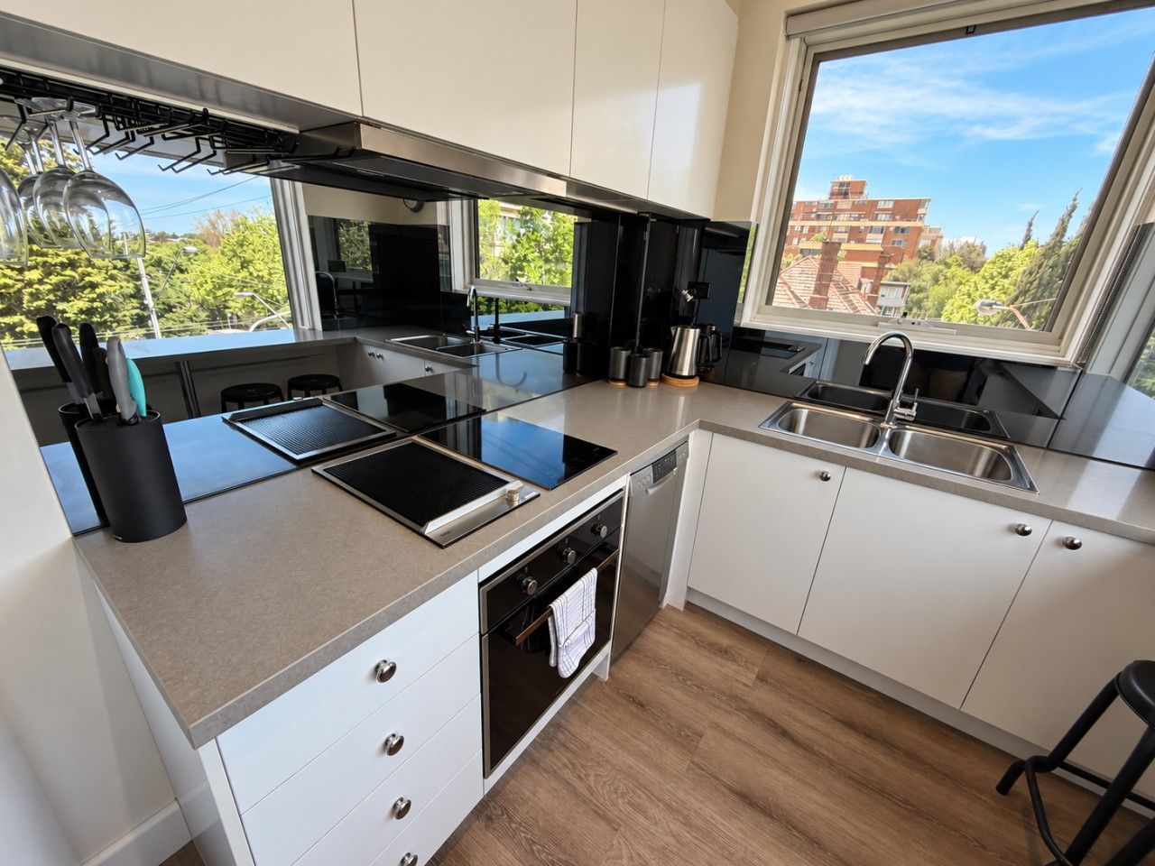 A modern kitchen with a built-in oven, a stovetop, and a dishwasher.