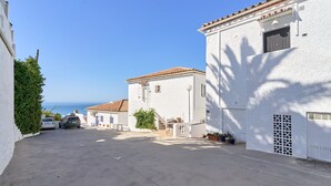 A narrow street with white buildings, a clear sky, and the sea in the background. - Holiday Home 'Casa Del Sol' with Sea Views, Wi-Fi and Air Conditioning (Nerja)