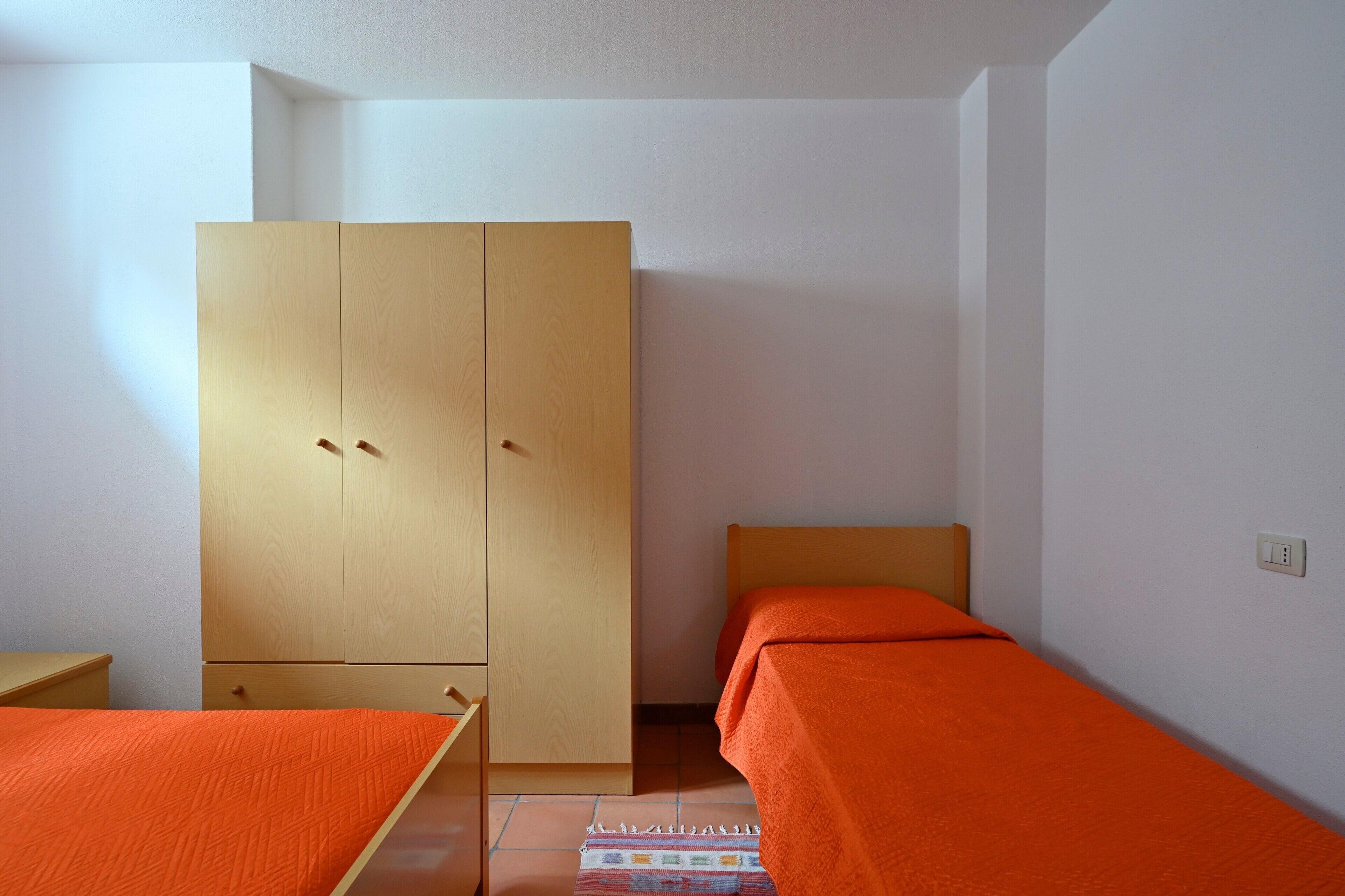 Een kamer met een bed, een kledingkast en een klein tafeltje.