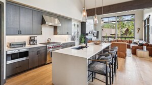 A modern kitchen with a central island, stainless steel appliances, and a large window overlooking a scenic landscape. - Chateau Breck: Luxury Townhome, Hot Tub & Fire Pit, Five-Peak Views. (Breckenridge)