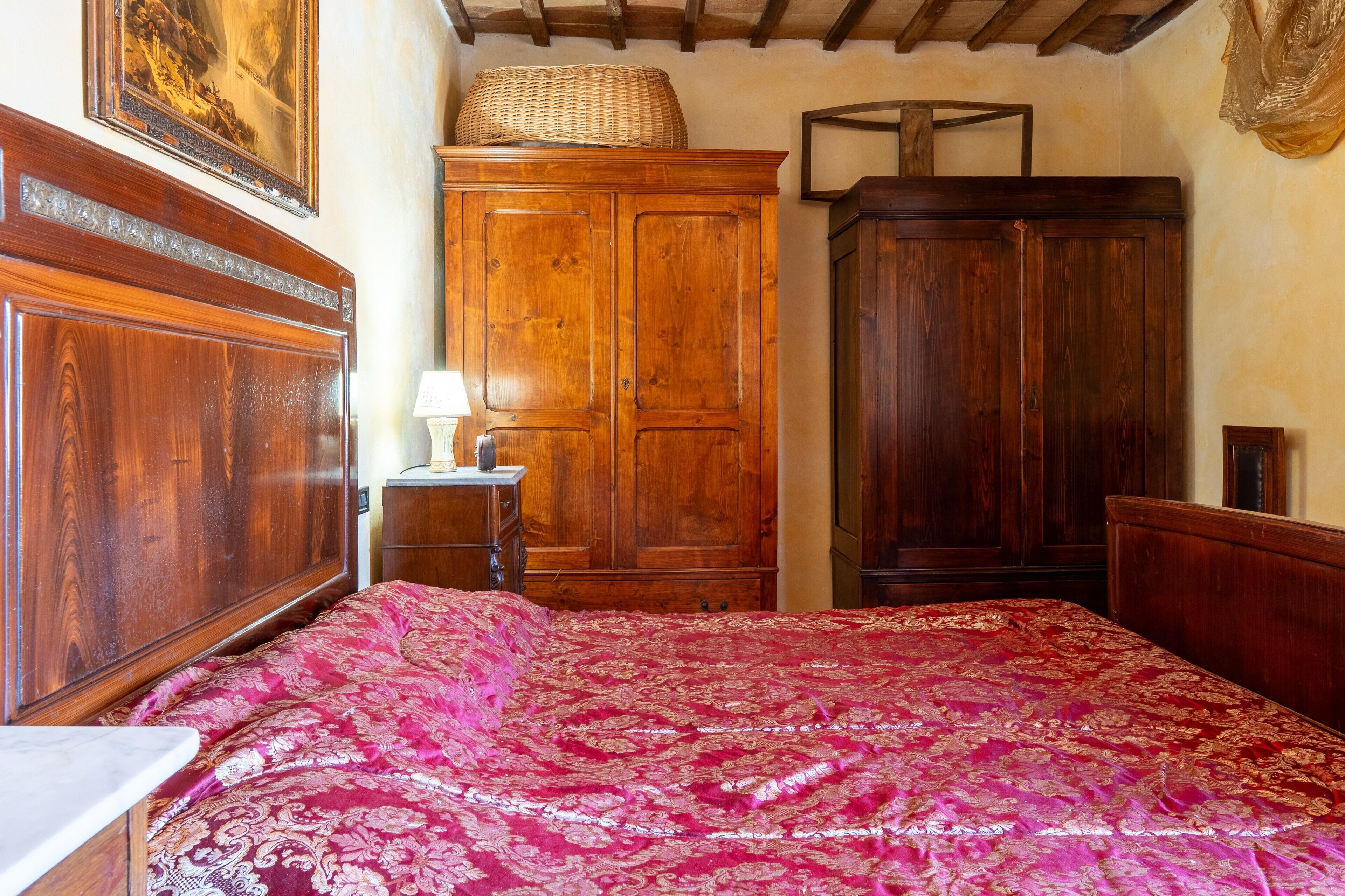 Ein Schlafzimmer mit einem hölzernen Bett, einem Schrank und einem Holzschrank.