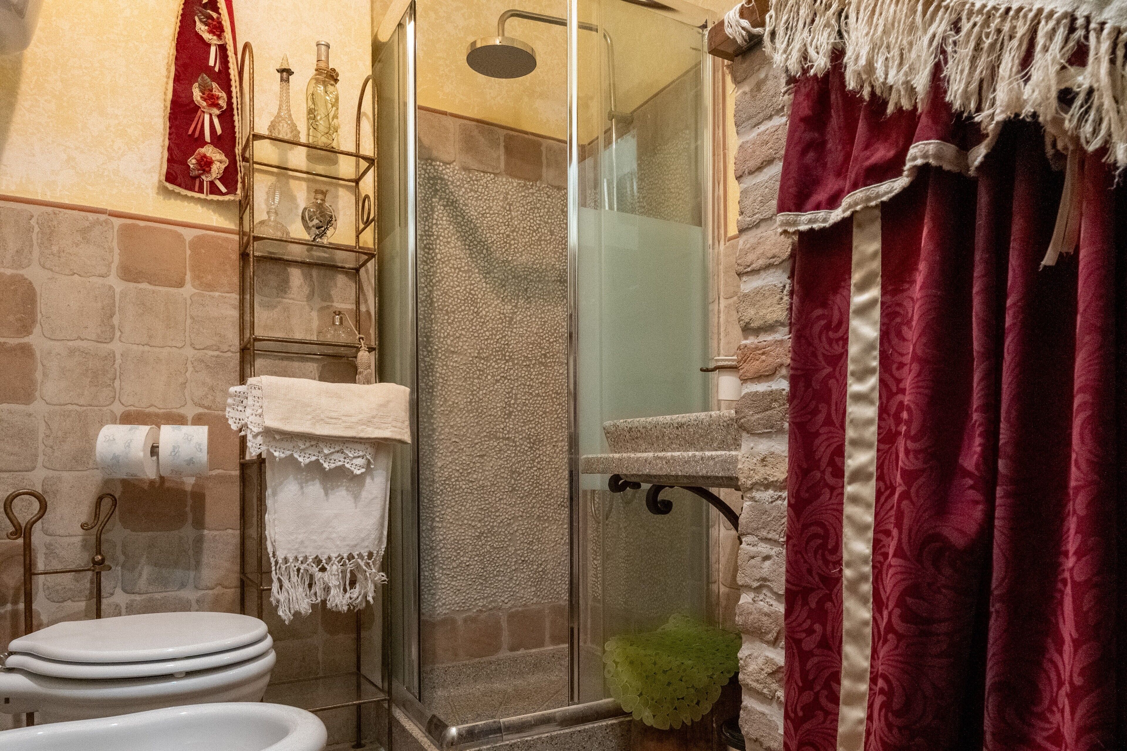 Une salle de bain avec une douche à parois de verre, des toilettes, un lavabo et un porte-serviettes.