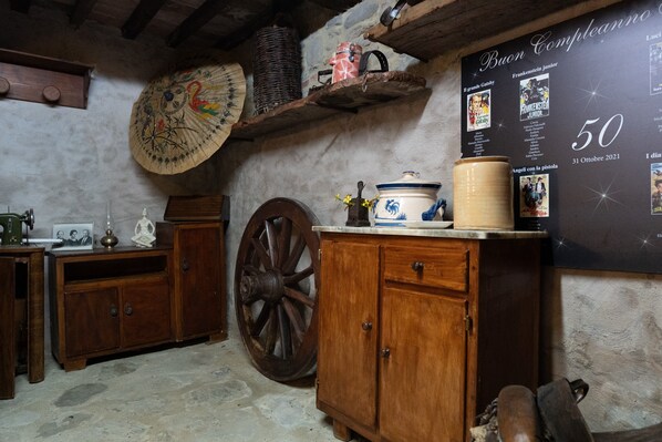 A rustic room with wooden cabinets, a large wooden wheel, and a wall with movie posters.