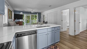 Una cucina moderna con lavastoviglie, lavello e mobili azzurri.