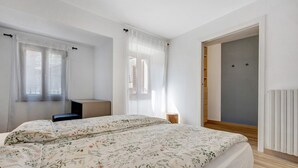 Ein Schlafzimmer mit Bett, Schreibtisch und Kleiderschrank.