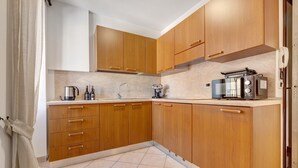 Eine Küche mit Holzschränken, einer Kaffeemaschine, einem Wasserkocher und einem Toaster.