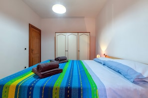 Une chambre à coucher avec un lit, une armoire et une table de chevet.