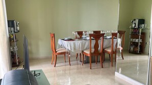 Comedor con una mesa dispuesta para cuatro personas, rodeada de sillas de madera.