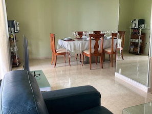 A dining area with a table set for four, surrounded by wooden chairs.