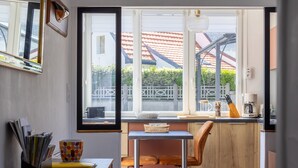 Een kleine keuken met een raam, een eettafel en een stoel.